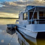 Sunset,Behind,Houseboat,On,Lake,In,Voyageur's,National,Park,In