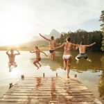 Portrait,Of,Young,Friends,Jumping,Into,The,Water,From,A
