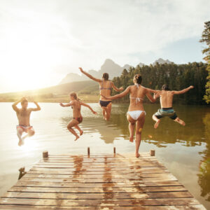 Portrait,Of,Young,Friends,Jumping,Into,The,Water,From,A