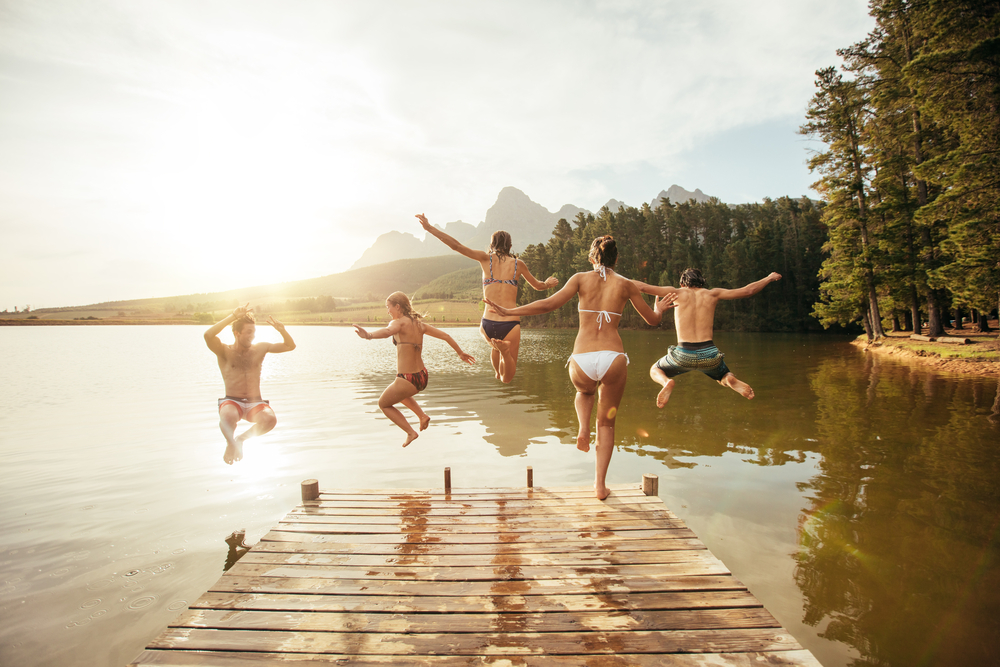 Portrait,Of,Young,Friends,Jumping,Into,The,Water,From,A