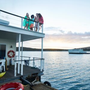 Young,Adult,Friends,Hanging,Out,On,Deck,Of,Summer,Houseboat