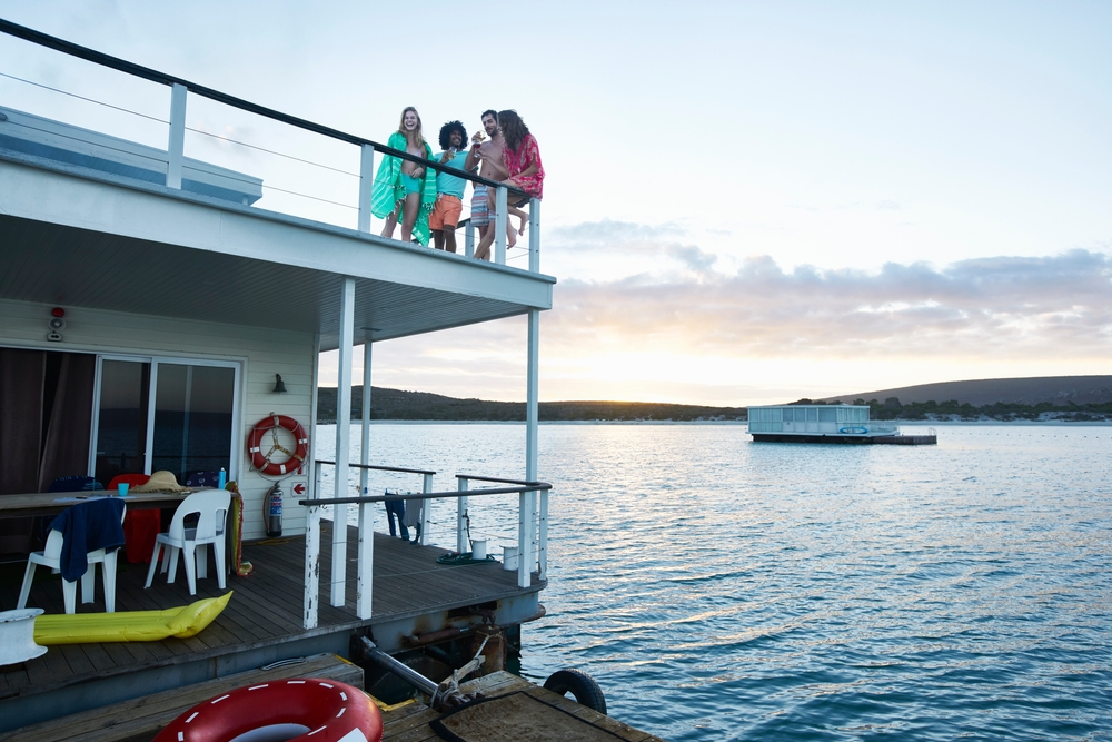 Young,Adult,Friends,Hanging,Out,On,Deck,Of,Summer,Houseboat