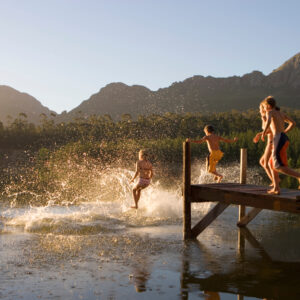 Horizontal,Shot,Of,A,Multi-generational,Family,Jumping,From,Jetty,Into