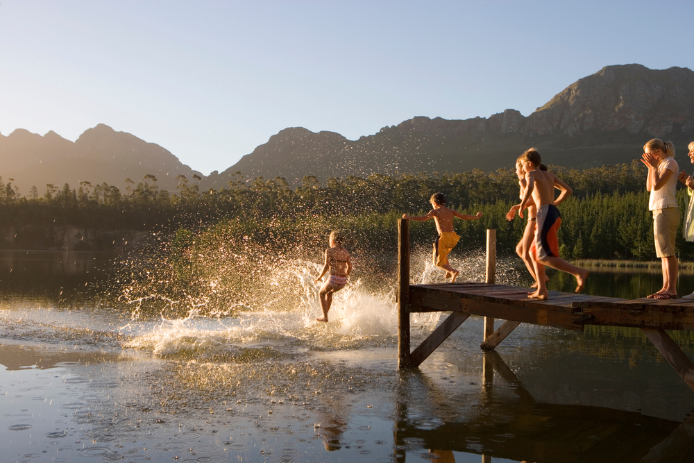 Horizontal,Shot,Of,A,Multi-generational,Family,Jumping,From,Jetty,Into